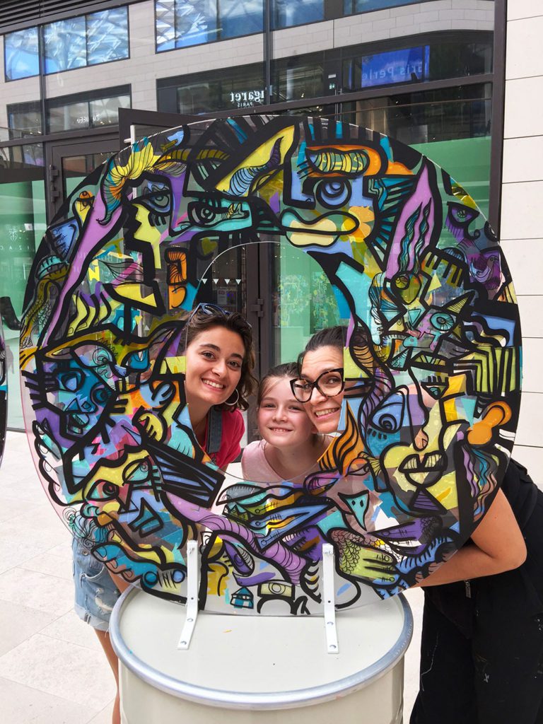 trois générations de femmes posent au milieu d'une œuvre d'art en forme de O