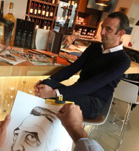 un modèle homme assis pose en face d'un caricaturiste qui le dessine sur feuille de papier format A3 en noir et blanc