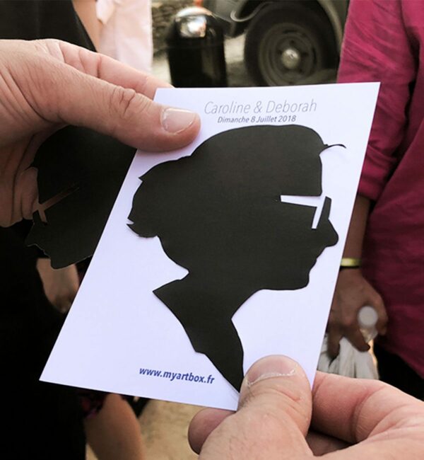 Image d'un animation portrait appelé silhouette de femme découpé sur du papier noir par un artiste my art box lors d'un mariage