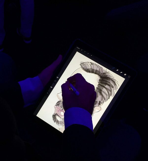 Photo d'un homme qui fait une caricature digitale en close up sur un iPad Pro