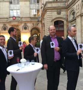 dans la cour de la mairie de Lyon, un groupe de 5 hommes en costumes lors d'un cocktail posent pour présenter dans leur main droite le cadeau reçu lors d'une animation portrait silhouette idée animation cocktail Lyon et toute la France