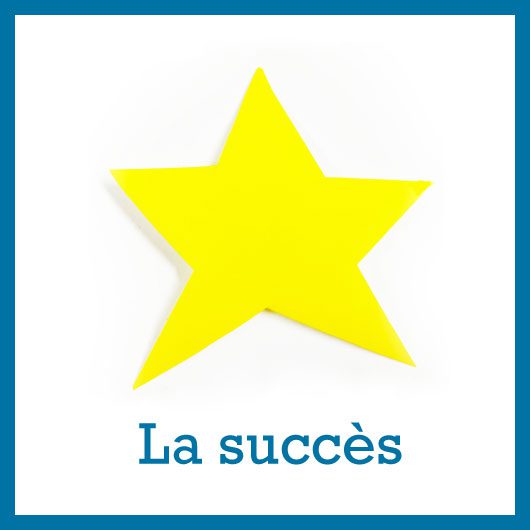 une étoile jaune à 5 branches découpée dans du papier de couleur posée sur un fond blanc au dessus de l'inscription Le succès symbole fort d'après confinement