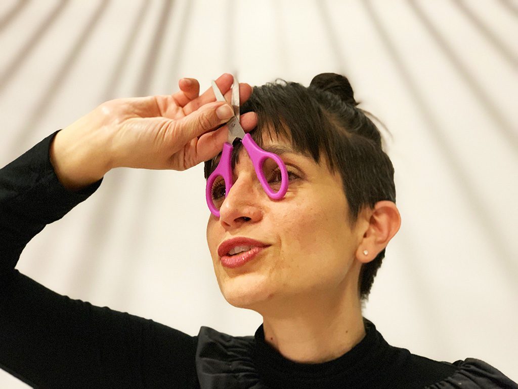 l'artiste aNa joue avec une paire de ciseaux qu'elle transforme en lunettes pour faire un poisson d'avril
