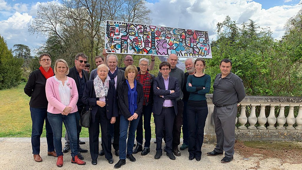 un groupe tient un tableau conçu en team building fresque commune disponible sur salon préventica