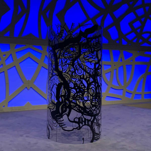 Un tube géant transparent avec dessin noir Totem Box XL exposé roulé sur la scène d'un amphithéâtre à Rouen avant une Animation Fresque My Art Box.