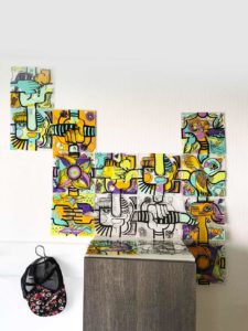 oeuvre commune par assemblage de carré de plexi décoratifs en forme libre fixée au mur au dessus d'un meublre