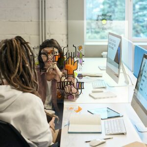 team building plexi entre deux femmes au bureau qui décore la paroi de séparation entre leurs postes de travail