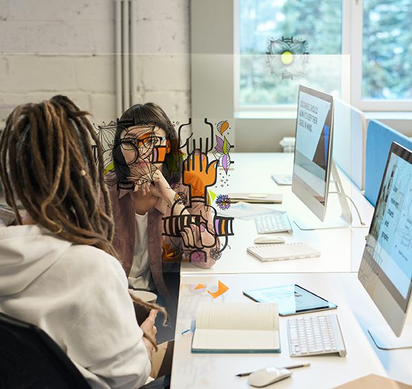 Paroi de protection plexiglass - La séparation qui crée du lien. 3 team building plexi entre deux femmes au bureau qui décore la paroi de séparation entre leurs postes de travail