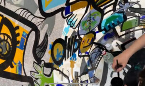 Team Building de Luxe aNa artiste Dans son tube plexi art qui devient une fresque géante une fois dépliée