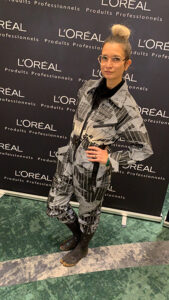 aNa artiste pose devant le photocall Loréal d'un team building précieux à Paris Versailles