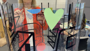 L'animation team building fresque des valeurs d'entreprise my-art-box se compose avec tous les symboles découpés des participants comme ce coeur vert collé sur le totem en plexiglas