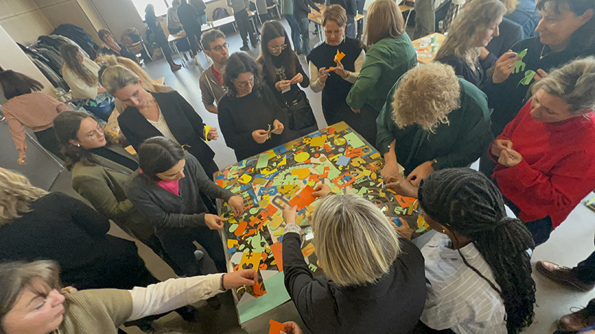 La Fresque de la Considération à Saint Etienne avec 100 collaborateurs 7 Les participantes au team building de la fresque de la considération My Art Box à Saint Etienne sont massées autour du plexi pour coller leurs réponses personnelles