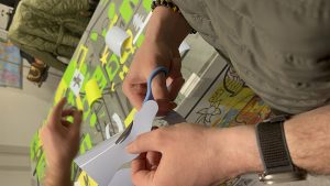 Une idée en train d'être découpée dans du sticker gris lors d'une animation fresque anniversaire entreprise à Genève