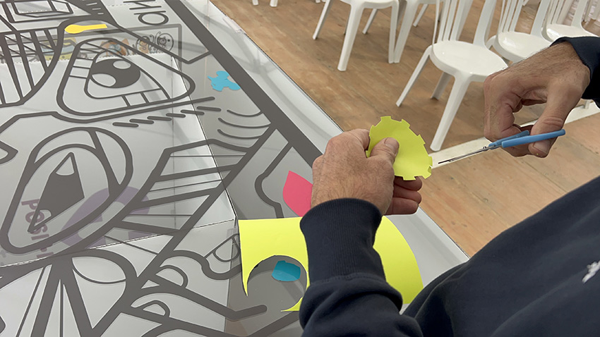 1 méthodique fresque du tri pour 100 personnes à Albi 13 Un symbole d'engrenage découpé dans du vinyle vert clair et collé sur la fresque du tri My Art Box pendant l'animation inaugurale à Albi
