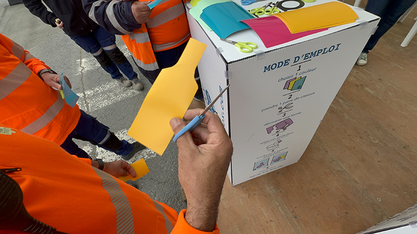 1 méthodique fresque du tri pour 100 personnes à Albi 5 Un pictogramme de bouteille découpé dans du vinyle orange et collé sur la fresque du tri My Art Box pendant l'animation inaugurale à Albi