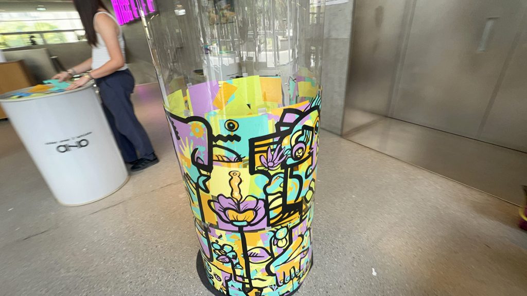 Le tube en plexiglas de l'artiste aNa pendant l'animation fresque éco-responsable à Genève par my Art Box