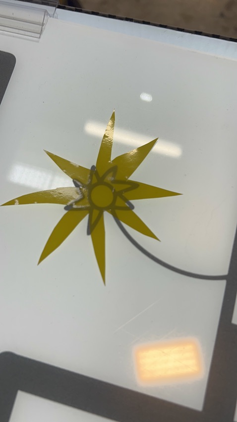 Un symbole de soleil en vinyle jaune découpé par une participante à la fresque zen de Cluny