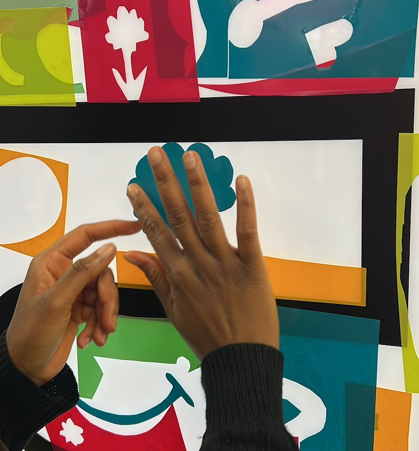 Gros plan sur les mains d'une participante sur le stand de la fresque plexi en cube pour animation amélioration continue à Paris ou en France