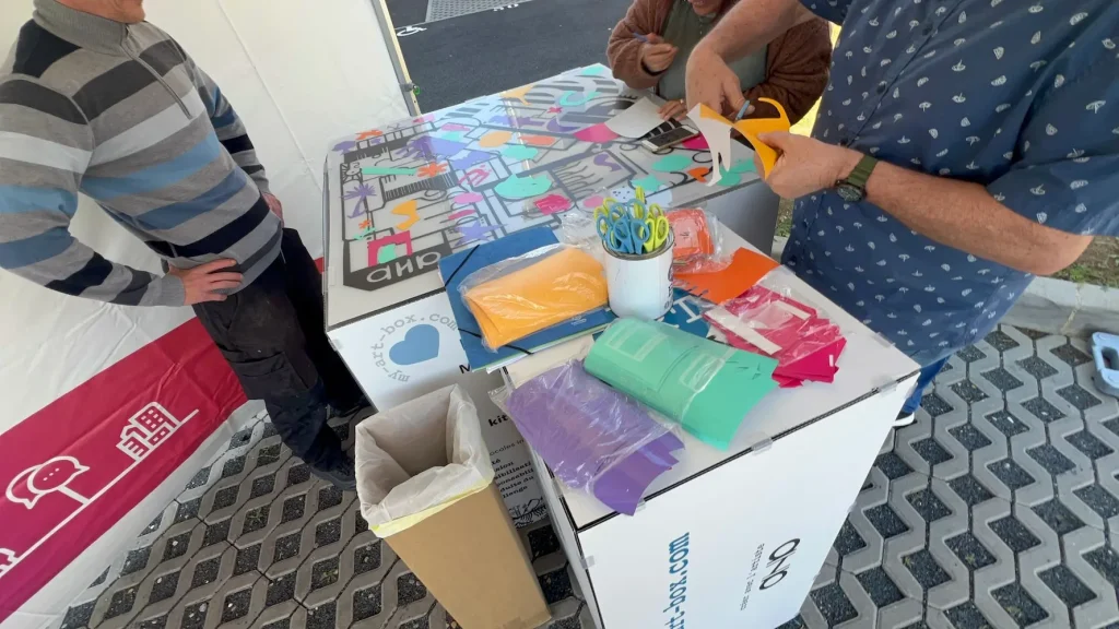 Participants découpant des formes en vinyle coloré lors d’une animation RSE pour inauguration immobilière sur support plexiglas réutilisable