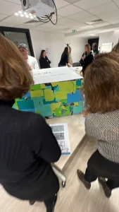 Groupe en animation de team building en équipes autour d’un cube collaboratif 4 faces My Art Box avec papiers colorés