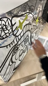 Main réalisant un collage sur un cube artistique My Art Box lors d’un team building en équipes à Paris
