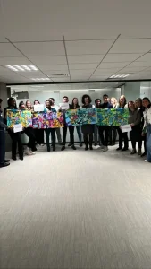 Groupe présentant des panneaux d’art colorés réalisés en team building en équipes avec My Art Box