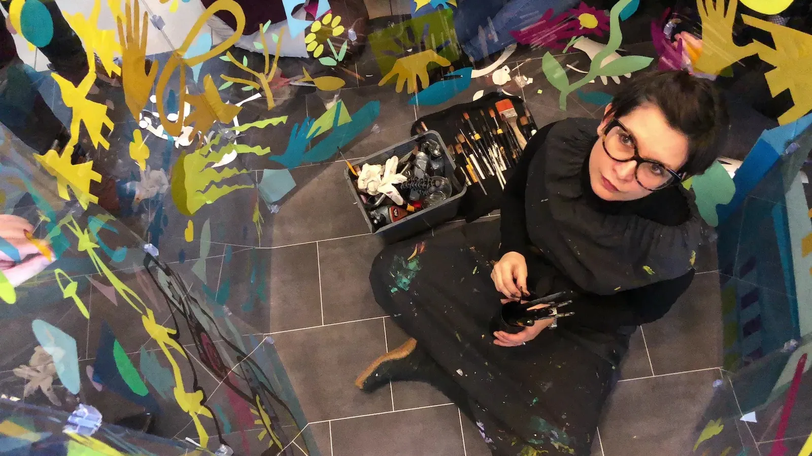 Artiste dans un tube de plexi créant une fresque, concept d'animation artistique my art box pour cohésion en Ile-de-France avec AXA.