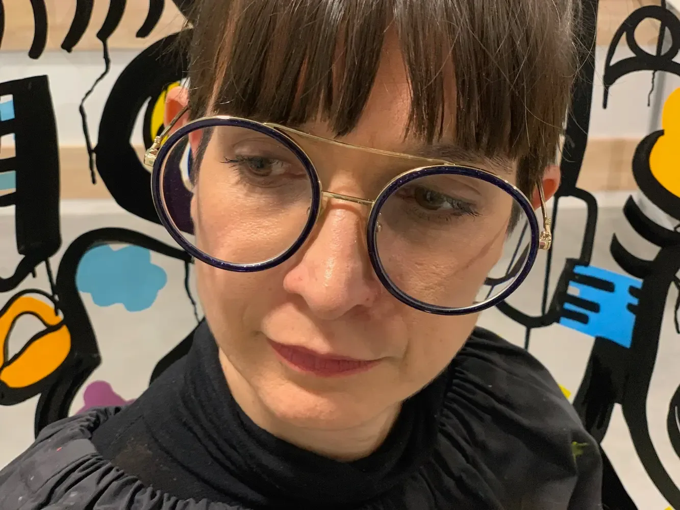 Portrait d'une artiste avec une fresque colorée en toile de fond, symbole d'une idée animation originale My Art Box pour inauguration à Lyon.
