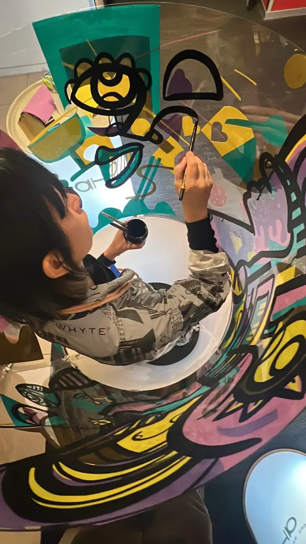 Personne créant une fresque sans peinture dans un cylindre en plexi au Palais des Congrès Paris