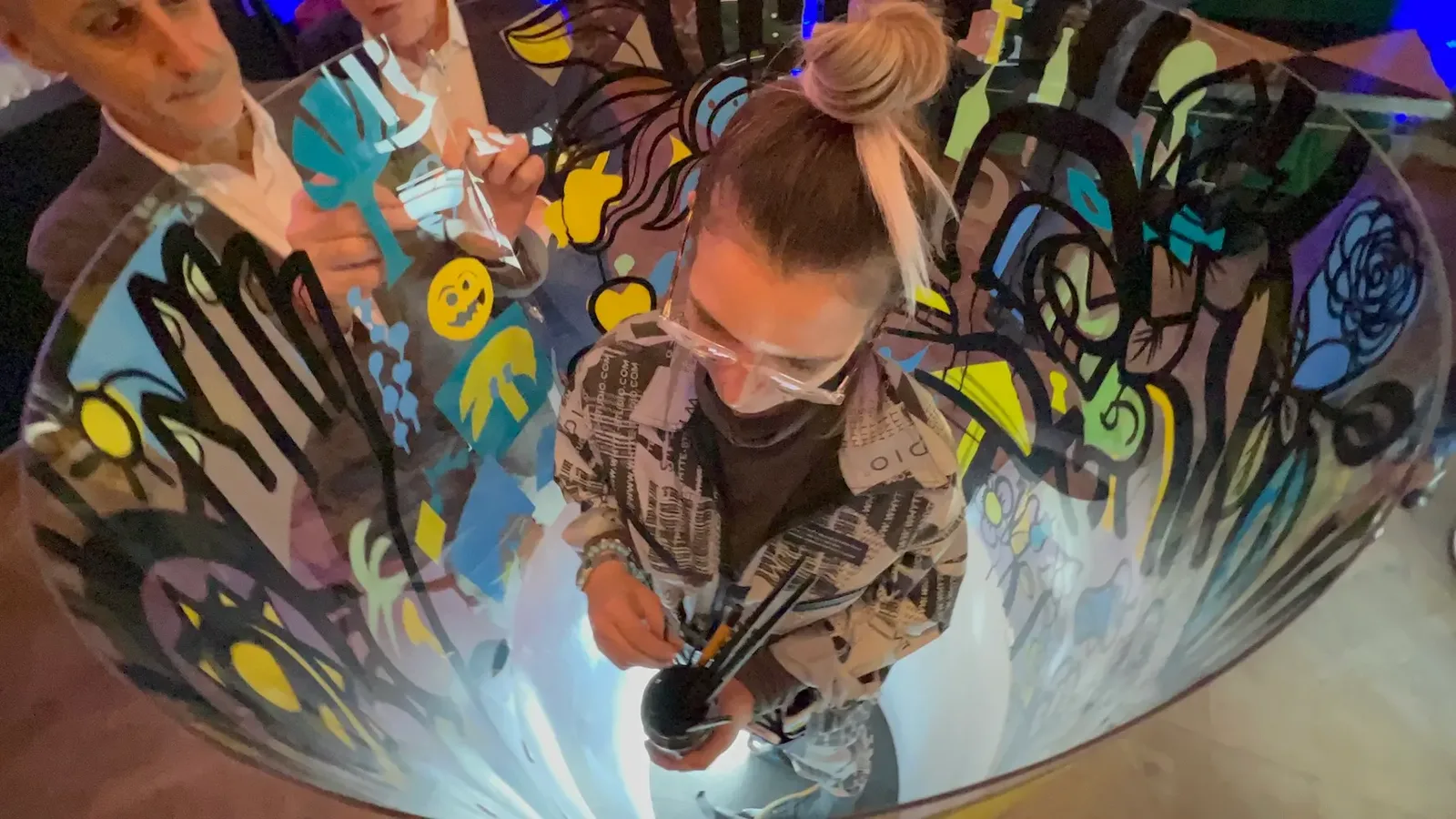Participant créant une fresque dans un tube à un anniversaire de cabinet d'avocats à Paris.