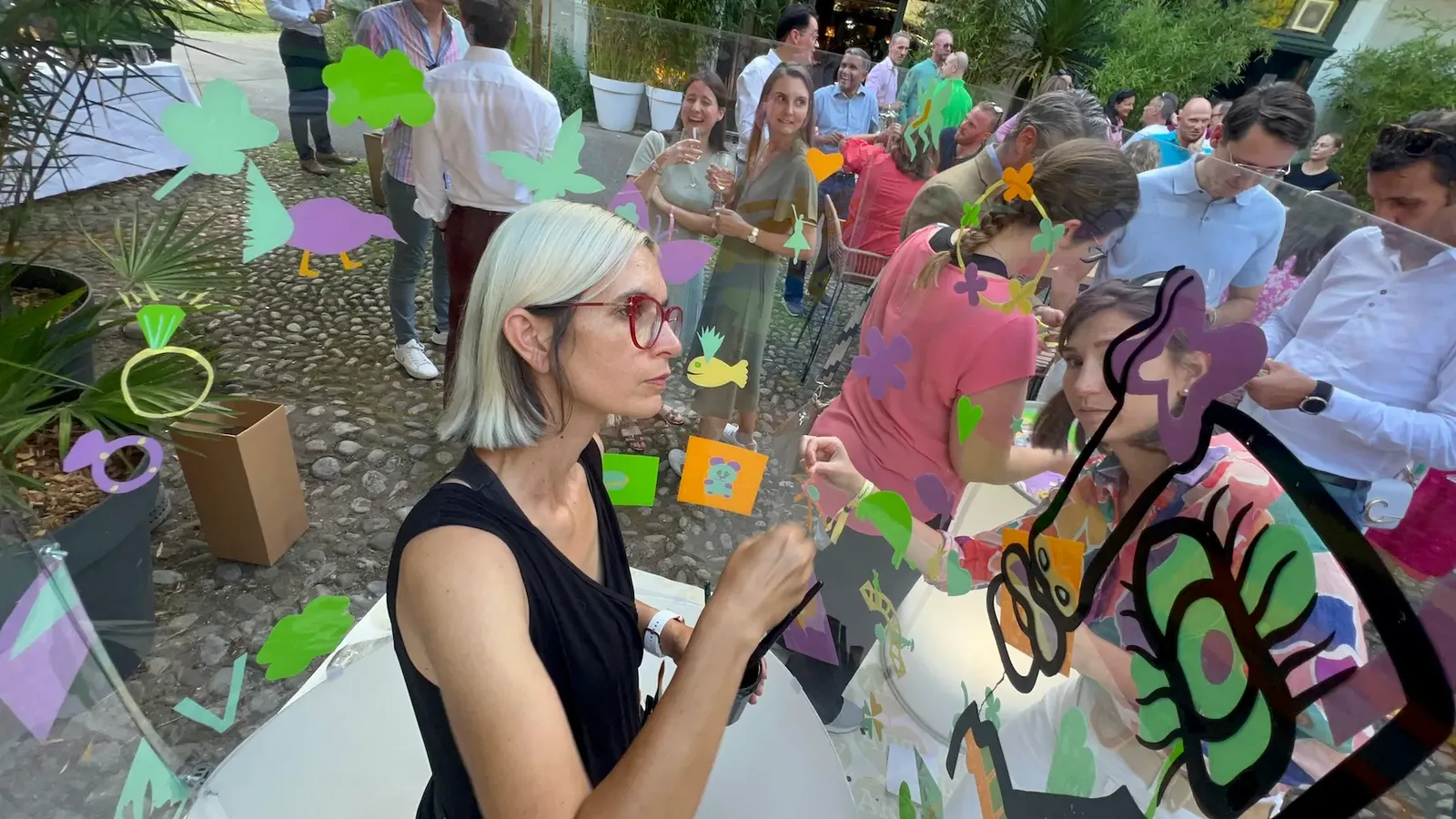 Animation artistique de cohésion My Art Box à Genève avec Van Cleef and Arpels, participants créant une fresque collective.