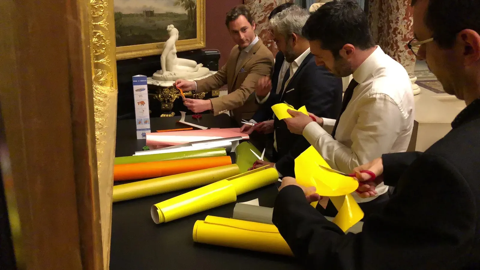 Participants découpant adhésifs colorés lors de l'animation de convention Pirelli au Château de Chantilly.