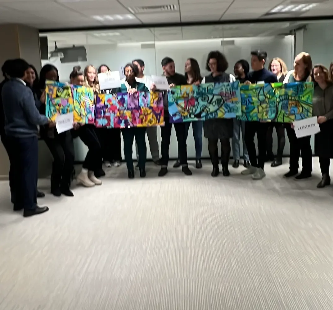 Participants tenant 4 tableaux colorés lors du team building artistique Paris Ogletree Deakins