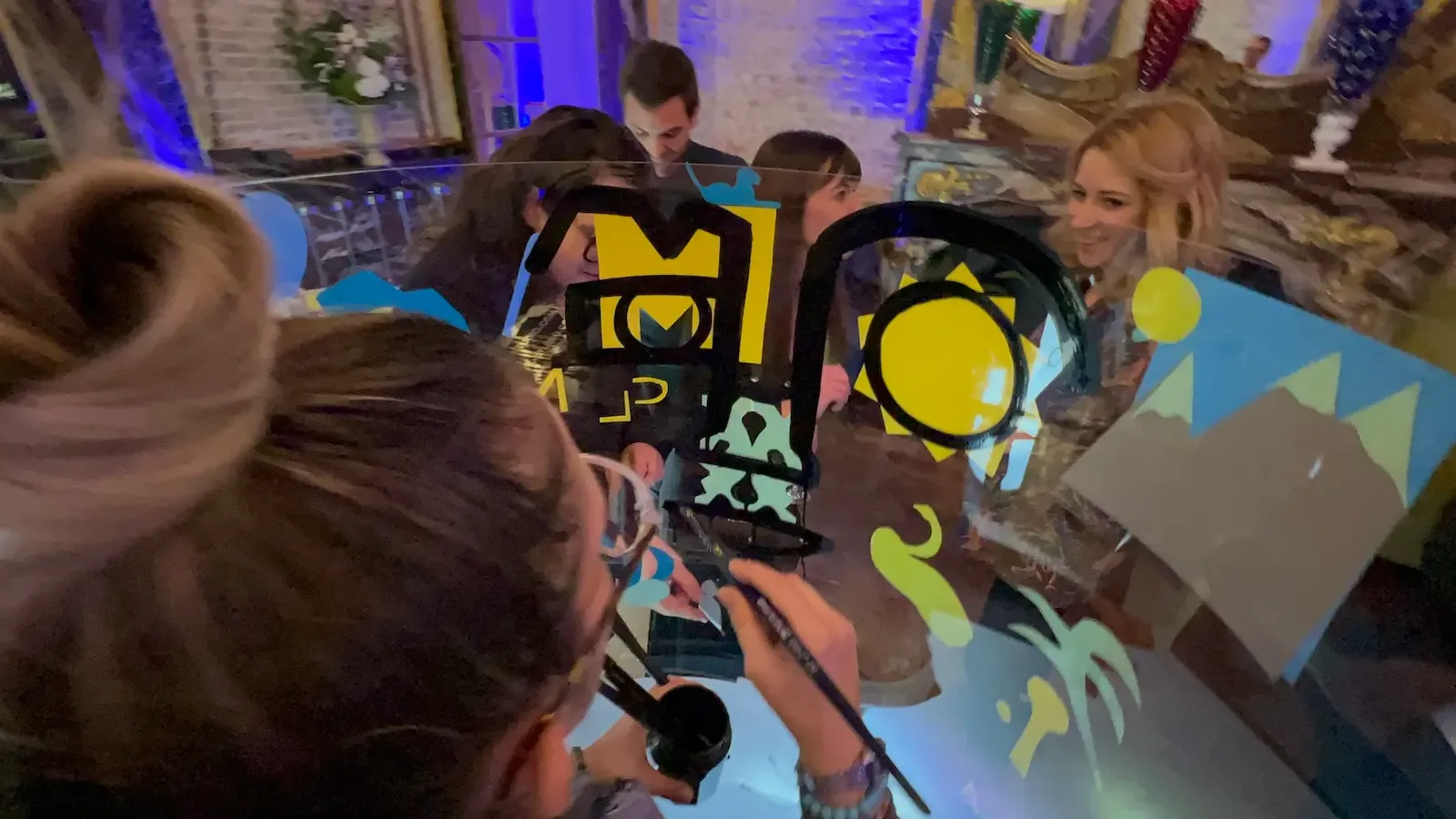 Participants créent une fresque écoresponsable lors d'un cocktail à Paris Baccarat, cadre original d'anniversaire.