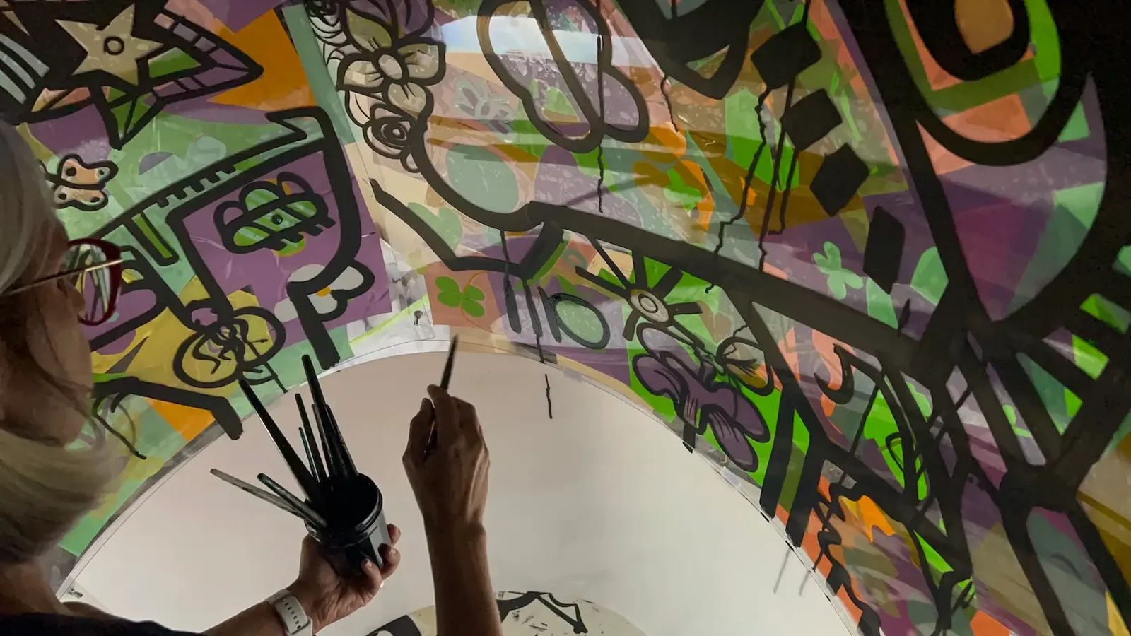 Artiste signant une fresque lors de l'animation cohésion à Genève avec Van Cleef and Arpels.