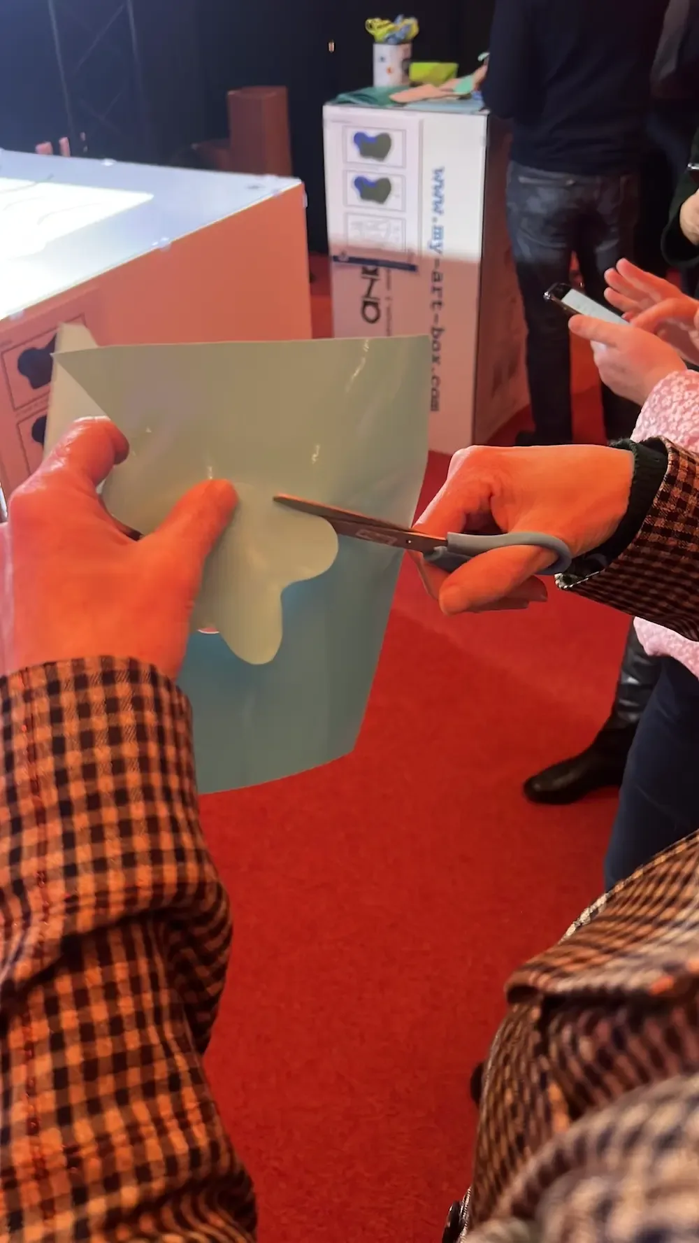 Participant découpe un nuage dans du vinyle bleu clair lors d'un cocktail artistique à Rouen.