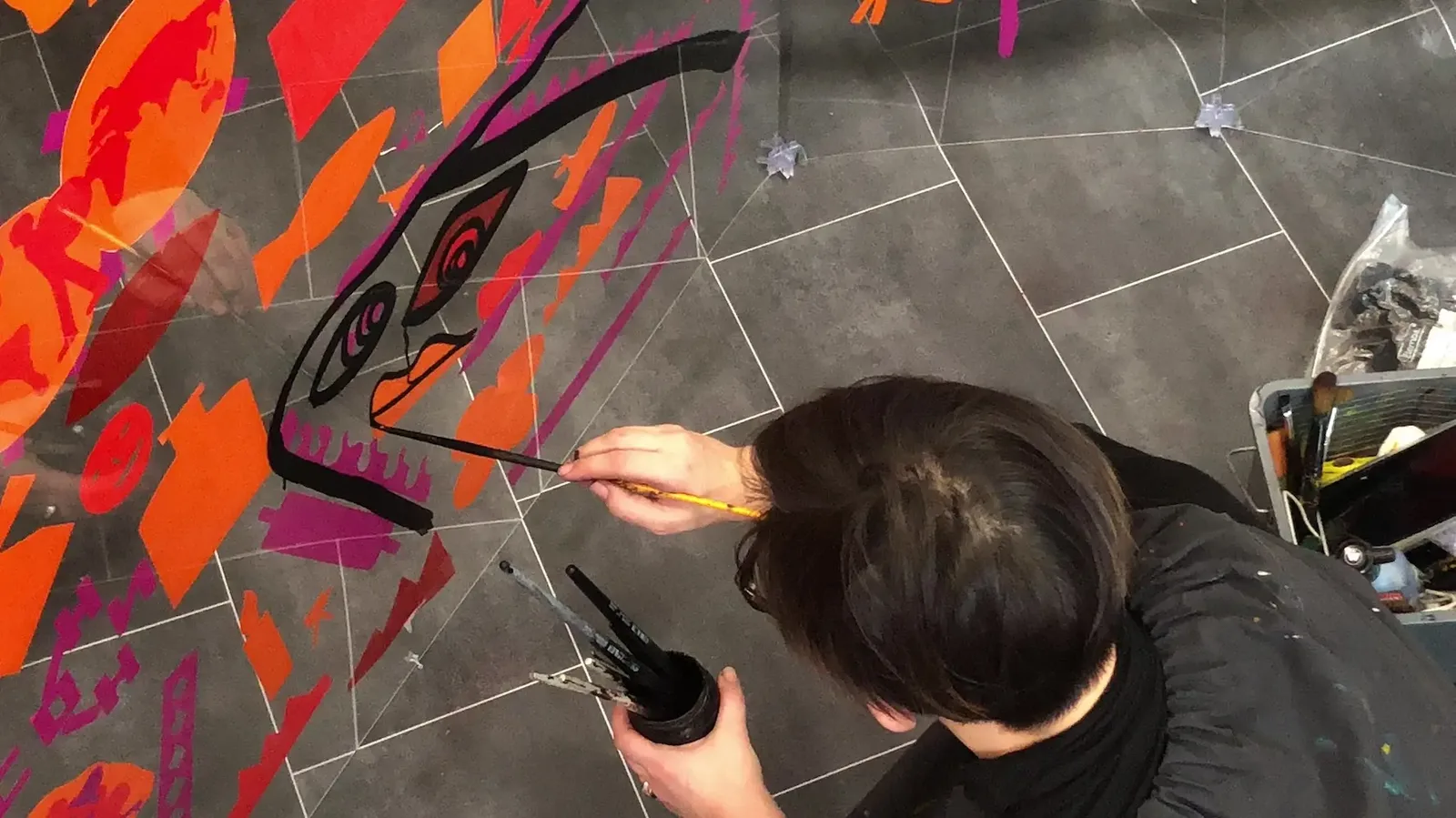 aNa artiste My Art Box créant une fresque vibrante dans un tube plexi.