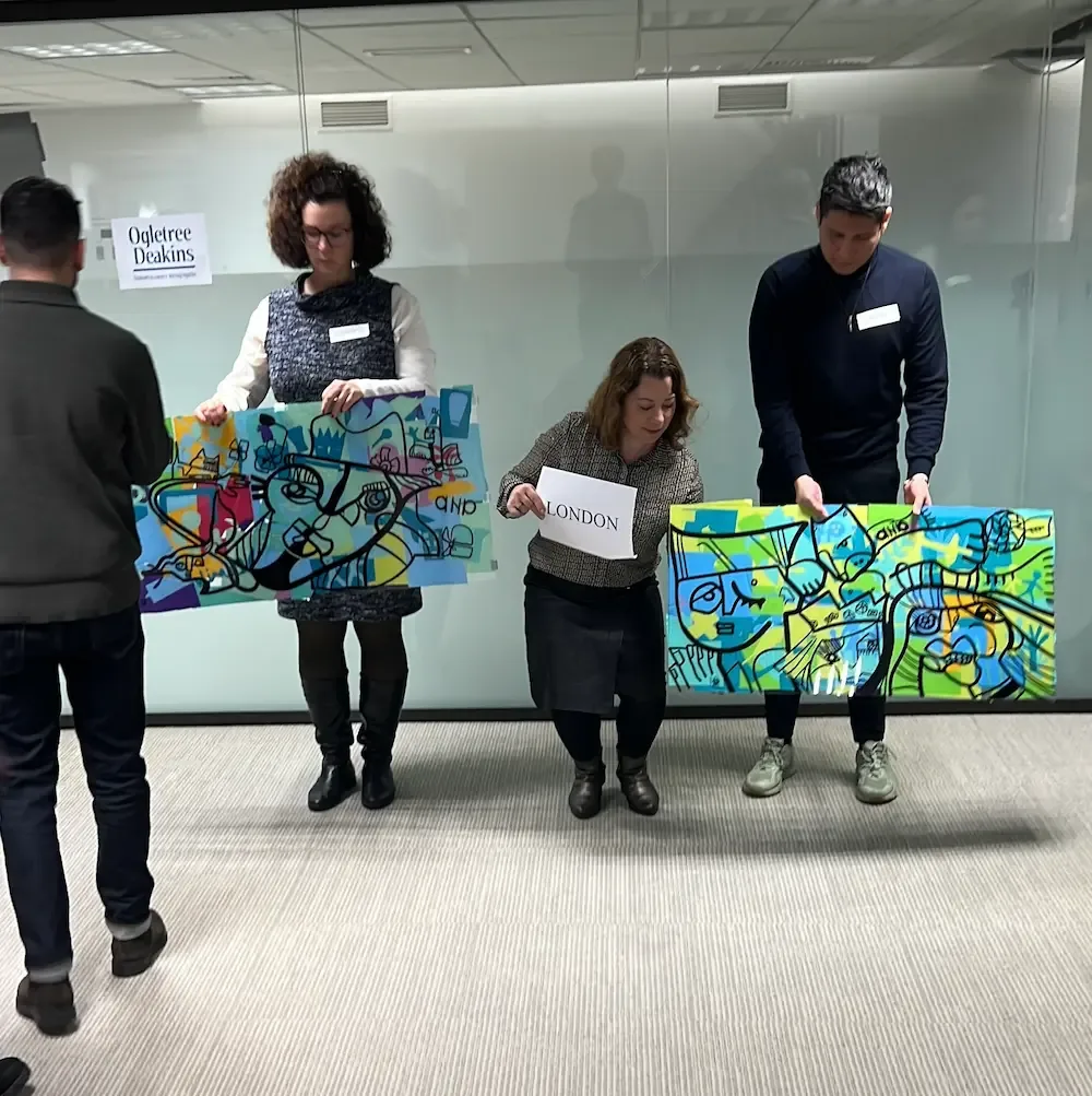 Participants d'Ogletree Deakins montrant des tableaux colorés lors d'un team building à Paris