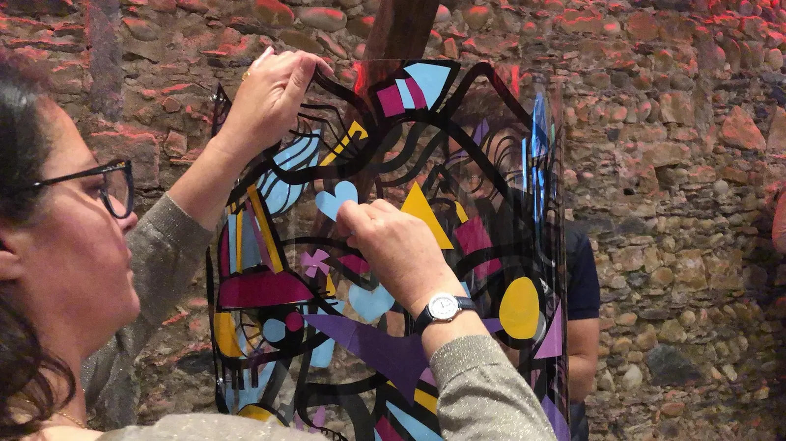 Participant collant un cœur bleu sur plexi avec My Art Box et aNa artiste