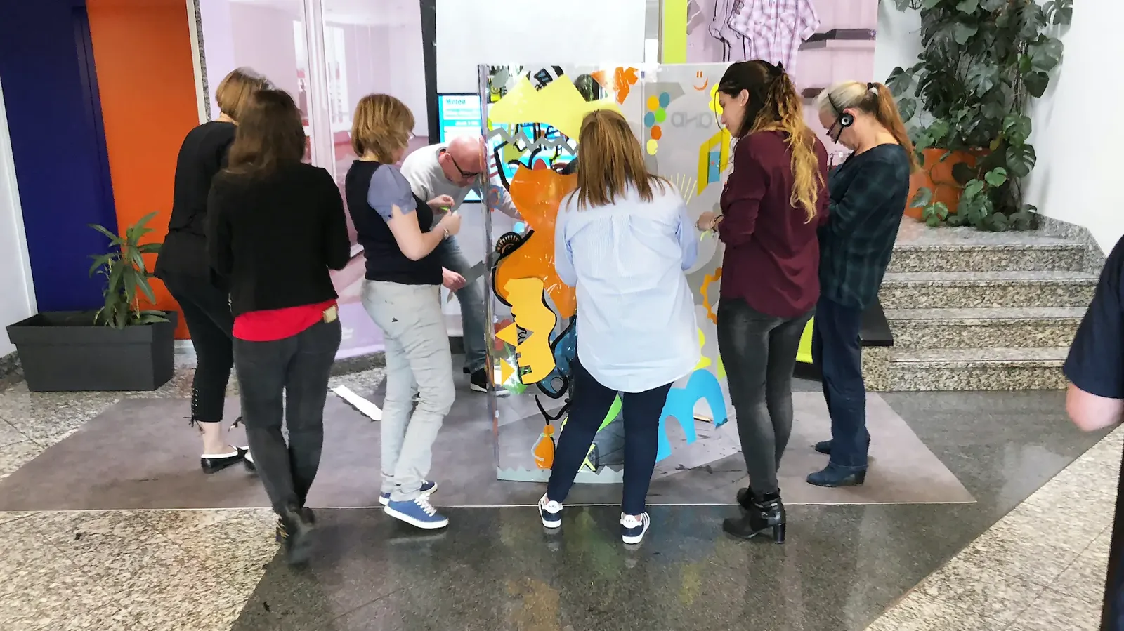 Participants autour d'un tube en plexi lors d'un team building avec My Art Box et aNa artiste.