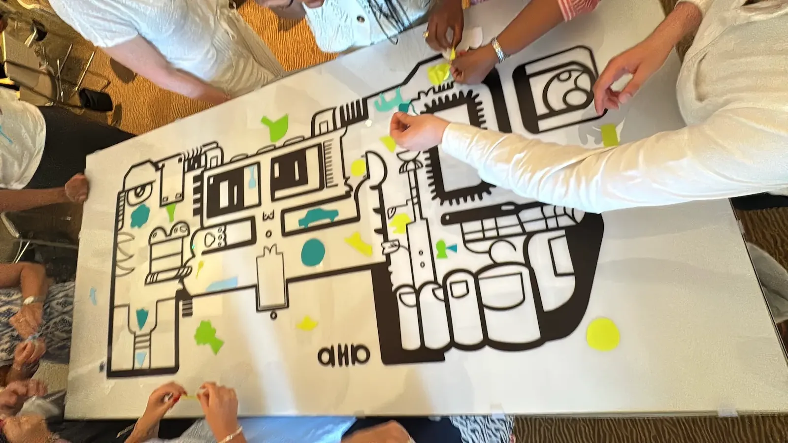 Participants collaborent sur une œuvre 'My Art Box' avec aNa artiste.