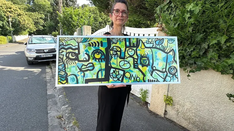 aNa artiste My Art Box tenant un tableau encadré après une animation anniversaire de 30 ans
