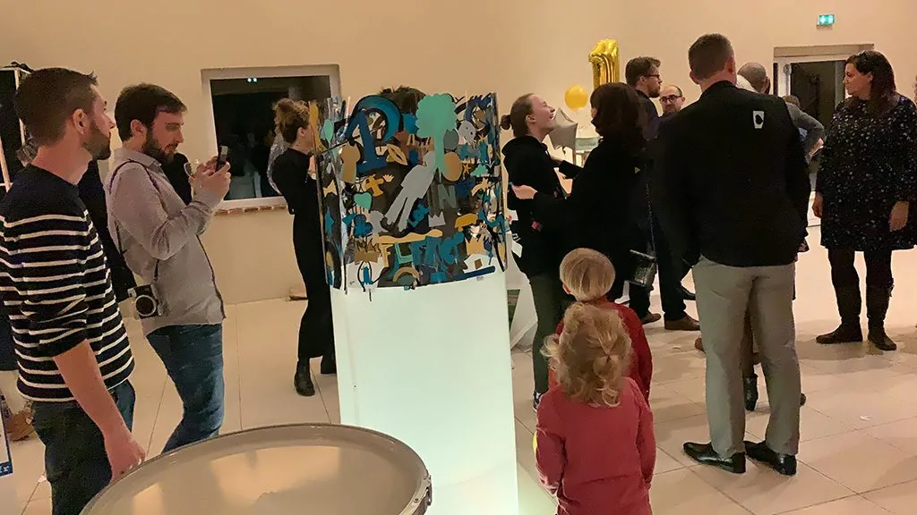Des invités participent à la création d'une œuvre d'art collective lors d'une fête d'anniversaire originale.