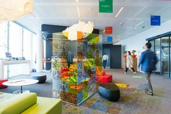 une paroi vitrée décorée de carrés colorés fresque open space installée au milieu d'un hall commun dans une entreprise