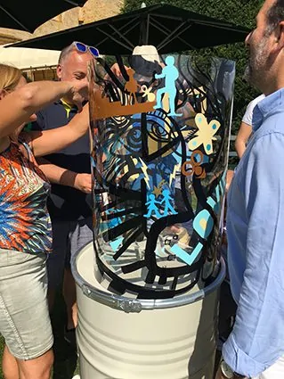 Participants s'initiant à la peinture sur un support transparent lors d'une animation artistique à Lyon.