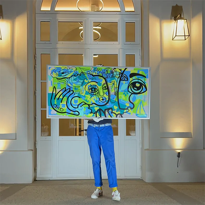 Invités réunis autour d'un support transparent pour créer une fresque colorée lors d'un anniversaire.