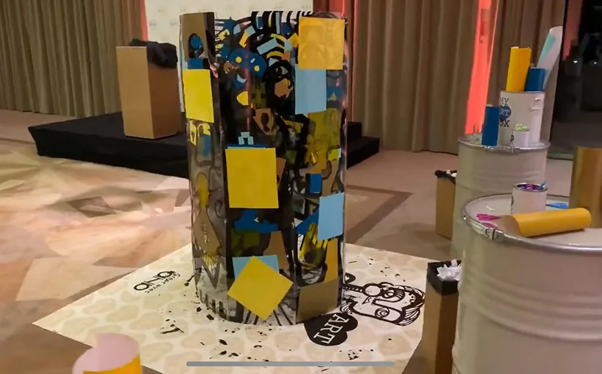 Participants assemblant des plaques de plexiglas colorées pour former une fresque totem géante lors d'un événement à Paris.