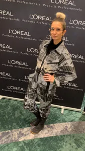 aNa artiste pose devant le photocall Loréal d'un team building précieux à Paris Versailles