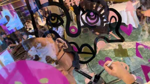 aNa artiste en son tube en plexiglas lors d'un Team building précieux fresque organisé à Versailles pour Loréal Paris par My Art Box