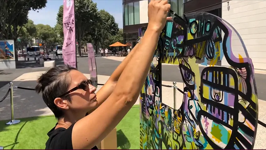 Participants personnalisant des lettres en plexiglas transparent avec des marqueurs colorés à Marseille avec aNa artiste.